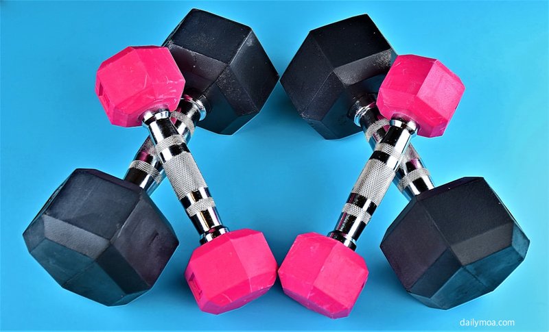 헬스장에서 바벨을 이용한 스쿼트 근력 운동을 하는 장면