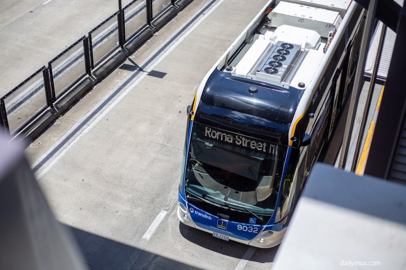 버스 정류장 안내판과 대기 중인 승객들